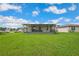 Spacious backyard with lush green grass and a covered patio, perfect for relaxation and activities at 3082 Forrest Plum Ct, Zephyrhills, FL 33540