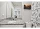 Bathroom with granite countertop and palm-themed shower curtain at 3082 Forrest Plum Ct, Zephyrhills, FL 33540