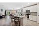 Modern kitchen with white cabinets, granite countertops, and an open layout flowing into the dining and living areas at 3082 Forrest Plum Ct, Zephyrhills, FL 33540