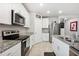 Well-lit kitchen with white cabinetry, granite countertops, and stainless steel appliances at 3082 Forrest Plum Ct, Zephyrhills, FL 33540