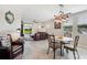 Open concept living room with tile flooring and a modern light fixture above the dining area at 3082 Forrest Plum Ct, Zephyrhills, FL 33540