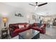 Bright living room with a red leather sofa, ceiling fan and modern decor throughout the space at 3082 Forrest Plum Ct, Zephyrhills, FL 33540