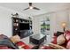 Cozy living room with a stylish entertainment center, ceiling fan and sliding glass doors to the patio at 3082 Forrest Plum Ct, Zephyrhills, FL 33540