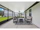 Covered patio with comfortable seating and a view of the well-manicured backyard at 3082 Forrest Plum Ct, Zephyrhills, FL 33540