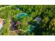 Aerial view of community tennis, volleyball, playground and basketball courts surrounded by mature trees at 31814 Larkenheath Dr, Wesley Chapel, FL 33543