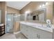 Bright bathroom features a double sink vanity, neutral walls, and a glass enclosed shower at 31814 Larkenheath Dr, Wesley Chapel, FL 33543