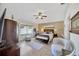 Bright bedroom features a seating area, light wood floors, ceiling fan, and a wardrobe at 31814 Larkenheath Dr, Wesley Chapel, FL 33543