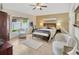 Bright bedroom features a seating area, light wood floors, ceiling fan, and a large window at 31814 Larkenheath Dr, Wesley Chapel, FL 33543