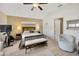 Bright bedroom featuring ceiling fan, light wood floors, seating, and ensuite bath at 31814 Larkenheath Dr, Wesley Chapel, FL 33543