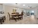 Inviting dining room features a long wood table, chandelier, and open access to living area at 31814 Larkenheath Dr, Wesley Chapel, FL 33543