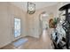 Elegant foyer with light wood floors, stylish lighting, and archway leading to the living spaces at 31814 Larkenheath Dr, Wesley Chapel, FL 33543