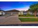 Charming single-story home with a well-manicured lawn and a two-car garage, under a beautiful twilight sky at 31814 Larkenheath Dr, Wesley Chapel, FL 33543