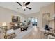 Bright living room featuring a leather sofa, ceiling fan, and sliding glass doors to patio at 31814 Larkenheath Dr, Wesley Chapel, FL 33543