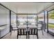 Enclosed patio featuring an outdoor dining area with views of the backyard and neighborhood at 31814 Larkenheath Dr, Wesley Chapel, FL 33543