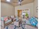 Inviting covered patio with wicker furniture, ceiling fan, and view of interior through sliding glass doors at 31814 Larkenheath Dr, Wesley Chapel, FL 33543