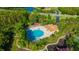 Aerial view of community pool and clubhouse, surrounded by lush landscaping and mature trees at 31814 Larkenheath Dr, Wesley Chapel, FL 33543