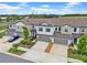 Aerial view of gray townhomes and landscaping with a blue car, blue sky, and wispy clouds at 3216 Bryant Park Dr, New Port Richey, FL 34655