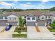 Aerial view of gray townhomes and landscaping with a blue car, blue sky, and wispy clouds at 3216 Bryant Park Dr, New Port Richey, FL 34655
