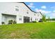 Backyard featuring green grass, new construction townhomes, and a treeline with blue sky at 3216 Bryant Park Dr, New Port Richey, FL 34655