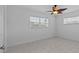 Bright bedroom featuring tile floors, two windows, and modern ceiling fan at 326 Circle Dr, Palm Harbor, FL 34683