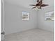 Bright bedroom featuring tile floors, two windows, and modern ceiling fan at 326 Circle Dr, Palm Harbor, FL 34683