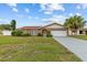 Charming brick home with a well-maintained lawn, arched entryway, and two-car garage, under a partly cloudy, blue sky at 326 Circle Dr, Palm Harbor, FL 34683