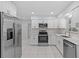 Modern kitchen with stainless steel appliances, white cabinetry, and tiled flooring at 326 Circle Dr, Palm Harbor, FL 34683