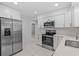 Updated kitchen boasts stainless appliances, white cabinets and a tile backsplash at 326 Circle Dr, Palm Harbor, FL 34683