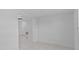 A brightly lit, white-painted room showcasing access to adjoining rooms and white tile flooring at 326 Circle Dr, Palm Harbor, FL 34683