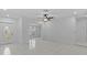 A spacious, sun-filled living area with white tile flooring, modern ceiling fan, and ample natural light at 326 Circle Dr, Palm Harbor, FL 34683