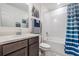 This bathroom features a vanity with a white countertop, a tub with white tile, and blue shower curtain at 344 Dartmouth Ave, Spring Hill, FL 34606