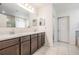 Bright bathroom featuring double sinks, a large mirror, and neutral tile flooring at 344 Dartmouth Ave, Spring Hill, FL 34606