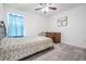 Cozy bedroom with carpet, a ceiling fan, metal bed frame and rustic dresser at 344 Dartmouth Ave, Spring Hill, FL 34606