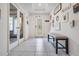 Bright foyer with decorative front door, tiled floor, high ceiling and bench at 344 Dartmouth Ave, Spring Hill, FL 34606