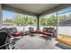 Relaxing screened-in porch with comfortable seating and view of a fenced backyard with mature trees at 344 Dartmouth Ave, Spring Hill, FL 34606