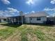 View of the backyard with screen patio area under the bright skies on a sunny day at 3541 65Th Avenue E Cir, Sarasota, FL 34243