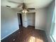 Bright bedroom featuring wood-look floors, a ceiling fan, and closet with wire shelving at 3541 65Th Avenue E Cir, Sarasota, FL 34243