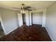 This bedroom features hardwood floors, a ceiling fan, an open closet and an adjoining room at 3541 65Th Avenue E Cir, Sarasota, FL 34243