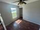 Well-lit bedroom featuring a ceiling fan, wood-look floors, and closet space at 3541 65Th Avenue E Cir, Sarasota, FL 34243