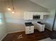 Bright kitchen with modern stainless steel microwave, white cabinets, dark countertops, and hardwood floors at 3541 65Th Avenue E Cir, Sarasota, FL 34243