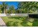 Beautiful backyard with lush green grass, a white fence, mature trees, and manicured landscaping at 3605 W Dale Ave, Tampa, FL 33609