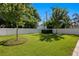 Beautiful backyard with lush green grass, a white fence, mature trees, and manicured landscaping at 3605 W Dale Ave, Tampa, FL 33609