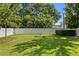 Beautiful backyard with lush green grass, a white fence, mature trees, and manicured landscaping at 3605 W Dale Ave, Tampa, FL 33609