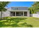 Expansive backyard featuring a screened lanai with outdoor kitchen, lush green grass, and privacy fence at 3605 W Dale Ave, Tampa, FL 33609