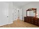 Well-lit bedroom featuring hardwood floors, white doors, and classic wooden dresser with a mirror at 3605 W Dale Ave, Tampa, FL 33609