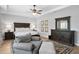 Spacious bedroom featuring dark wood furniture, a tray ceiling, a ceiling fan, and a sitting area at 3605 W Dale Ave, Tampa, FL 33609