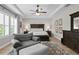 Bright bedroom with a tray ceiling, ceiling fan, wood floors, plantation shutters and a comfortable sitting area at 3605 W Dale Ave, Tampa, FL 33609