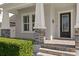 Inviting front porch with stone accents, featuring decorative pillars and a stylish glass-paneled front door at 3605 W Dale Ave, Tampa, FL 33609