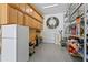 This garage has an epoxy floor, shelves, a refrigerator, and a lot of cabinets at 3605 W Dale Ave, Tampa, FL 33609