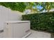 Generac generator on a concrete pad, surrounded by lush landscaping and a white fence at 3605 W Dale Ave, Tampa, FL 33609
